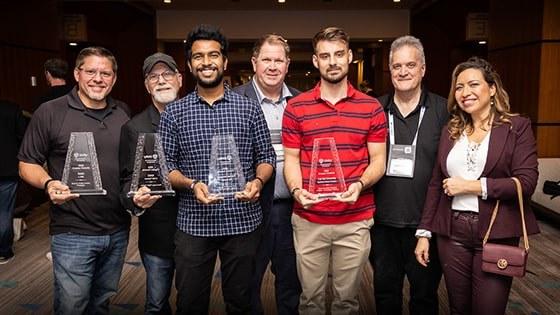 The recipients of the Made with Unity recognition award stand with their statuettes with Full Sail and Advent Health University course and education directors.